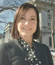 Gwen Ross smiling, with a building behind her