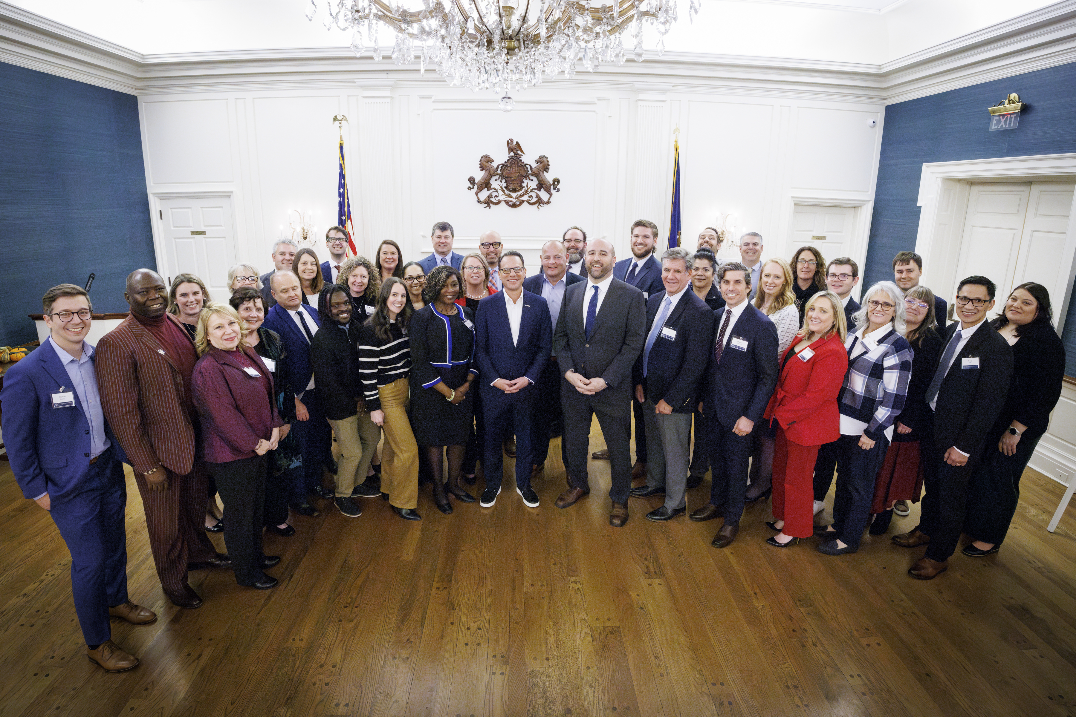 A group photo of the DCED BusinessPA team, alongside Governor Josh Shapiro, smiling at the camera during the BusinessPA Launch Reception at the Governor's Residence
