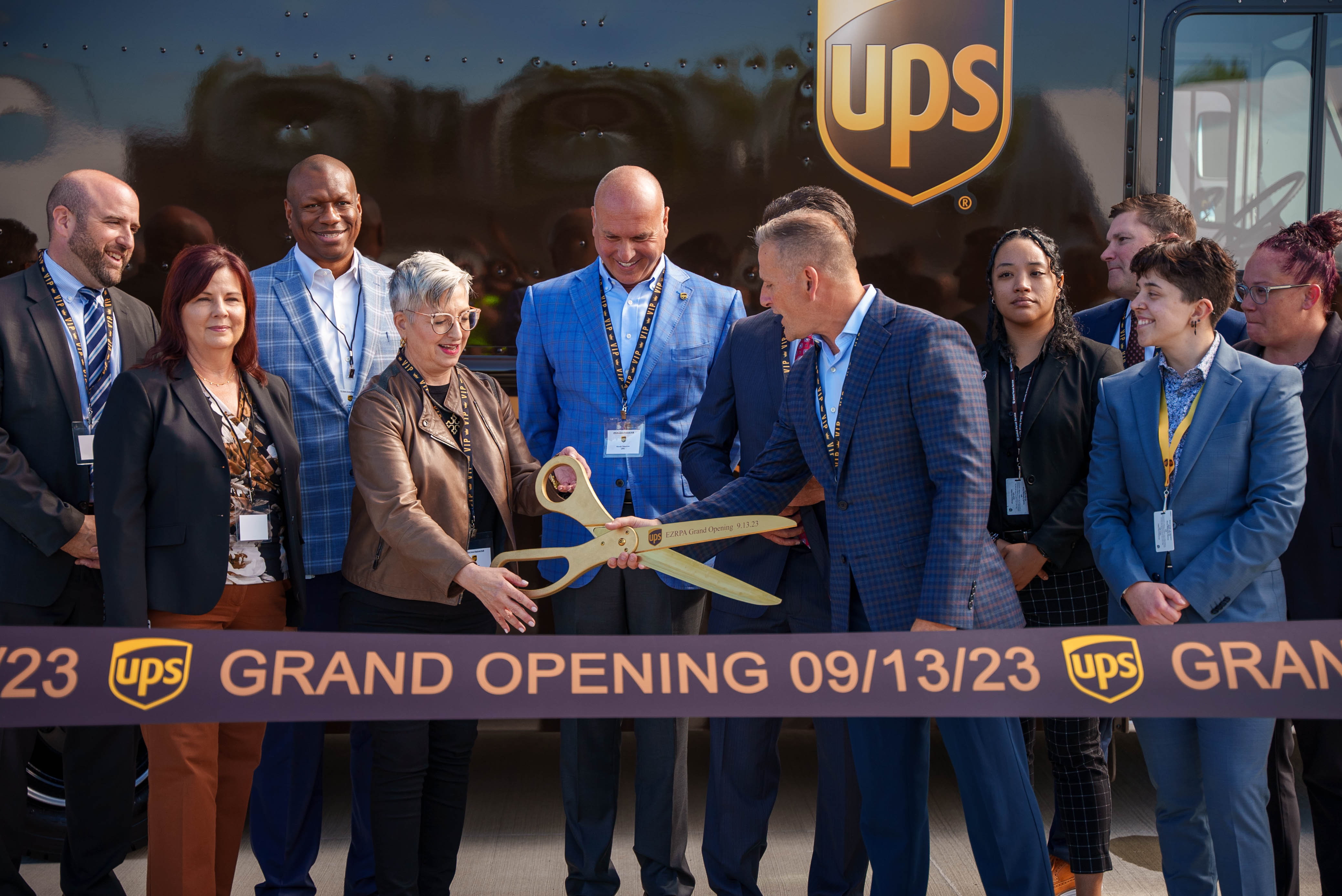 Governor Josh Shapiro with UPS employees cutting a ribbon at a grand opening ceremony