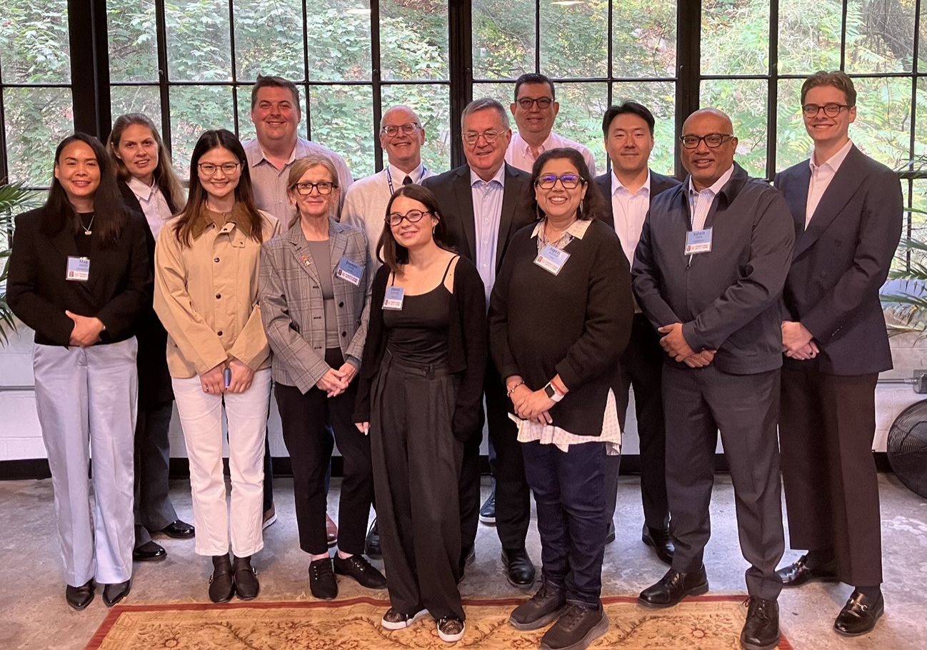 A group photo of international businesspeople smiling in an ornate balroom