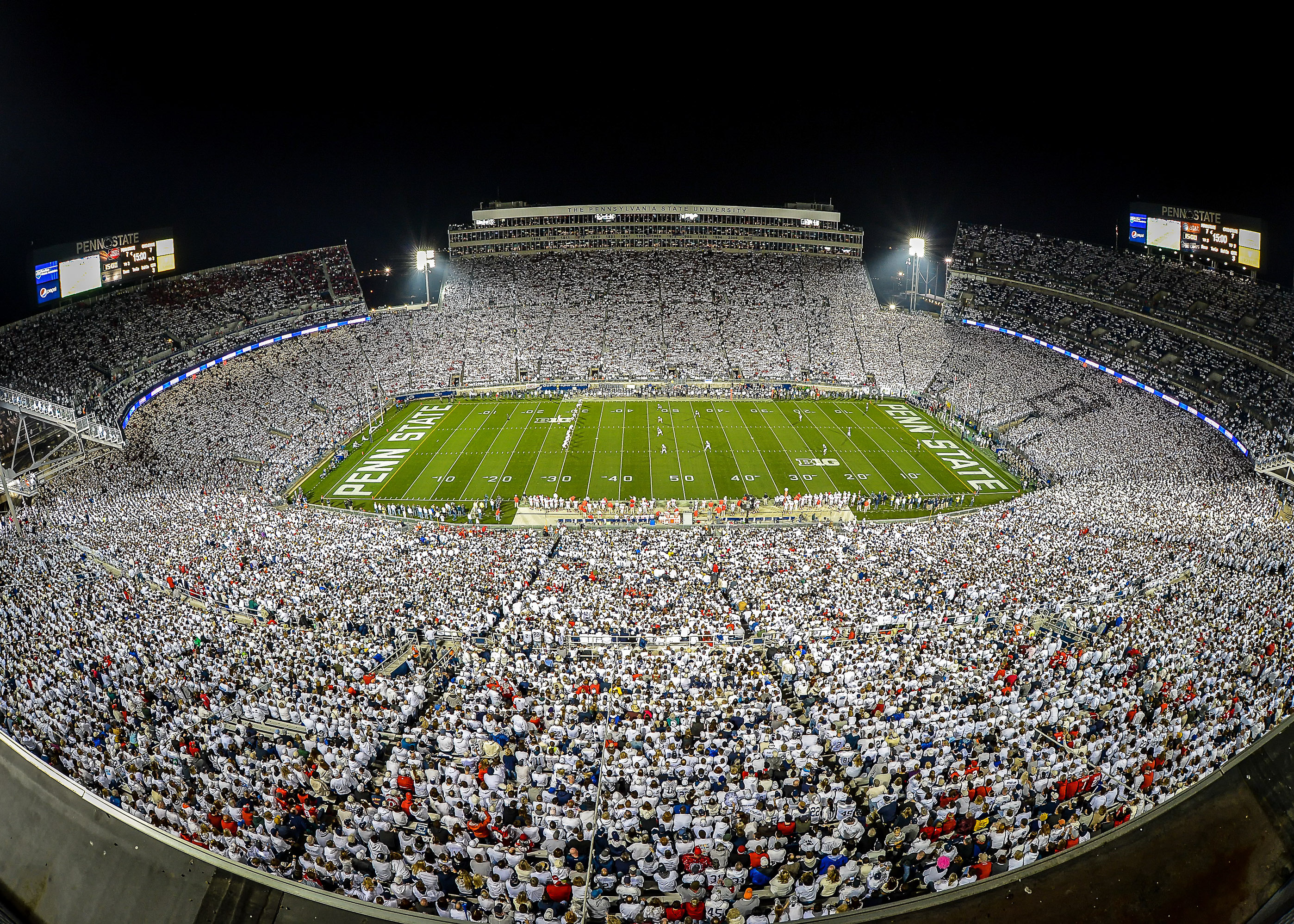 A crowded football stadium at night