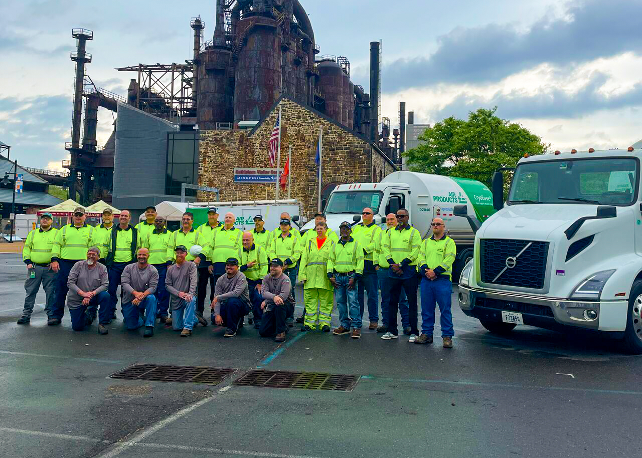 Construction crew posing near industrial plant