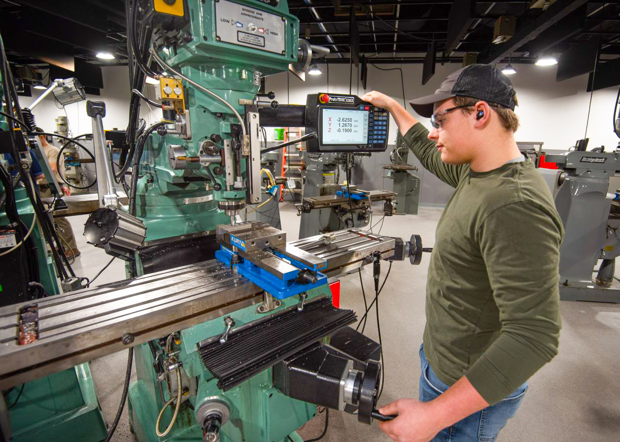 Operator using digital milling machine in workshop