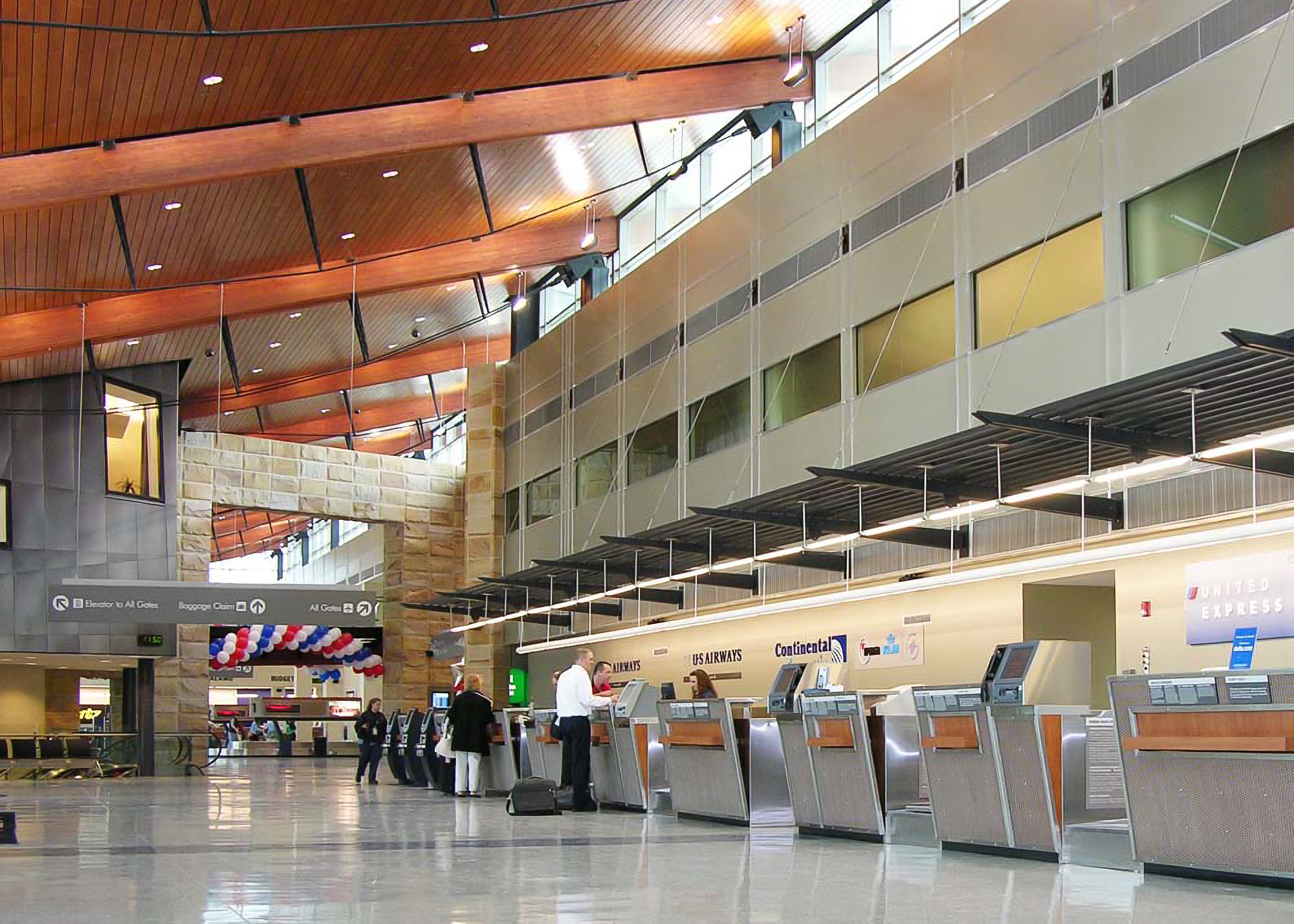 Modern airport check-in area with travelers and staff