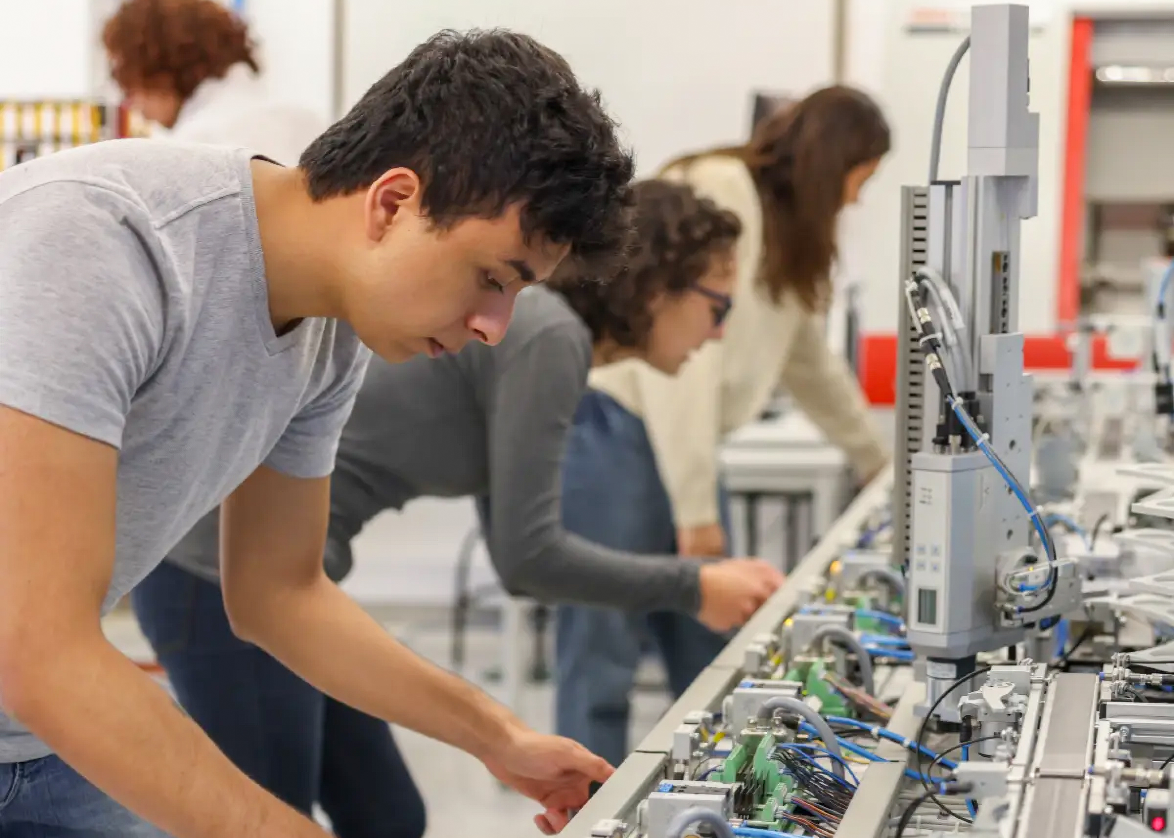 Young adults working on industrial automation equipment