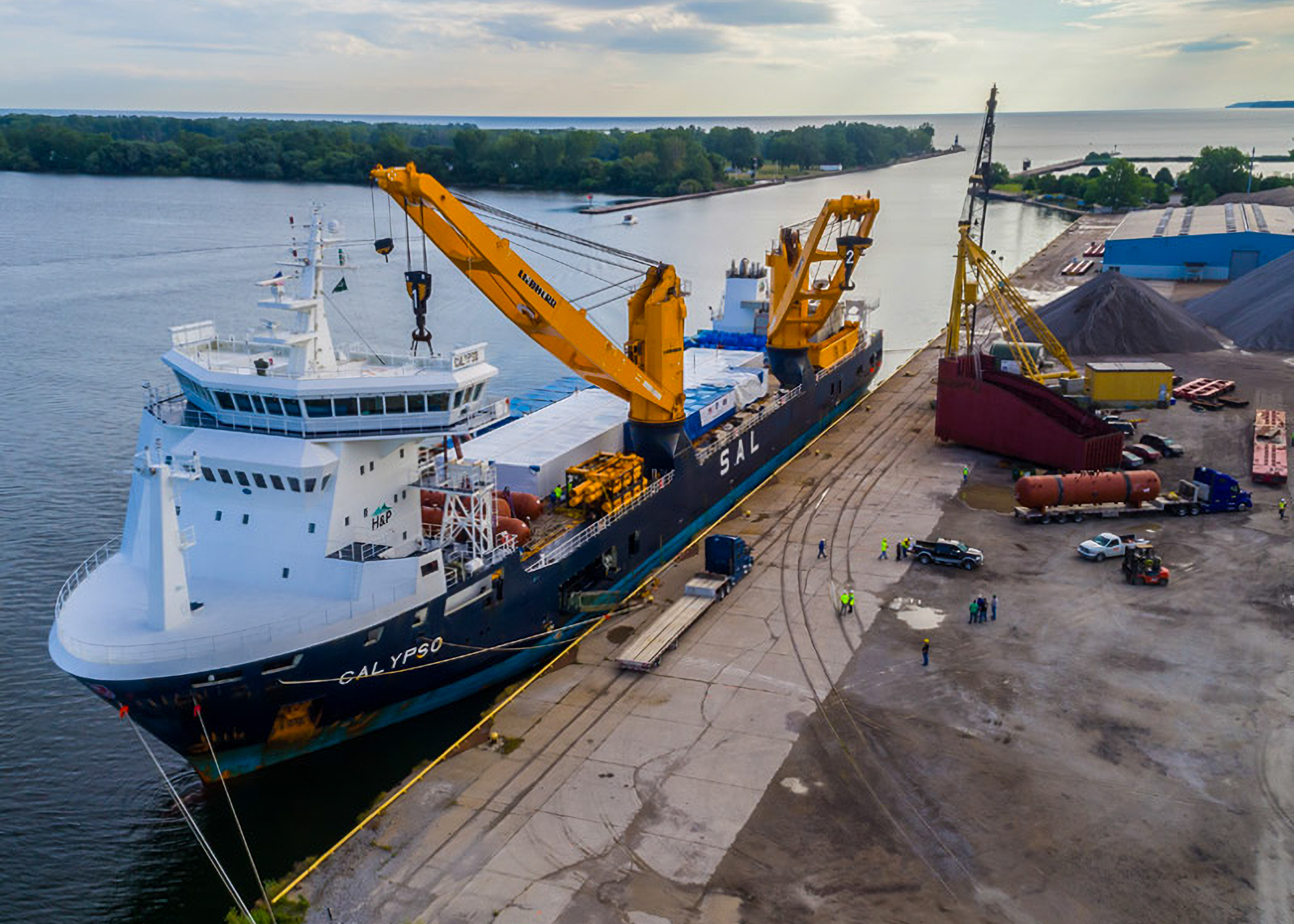 Cargo ship with cranes docked at industrial port