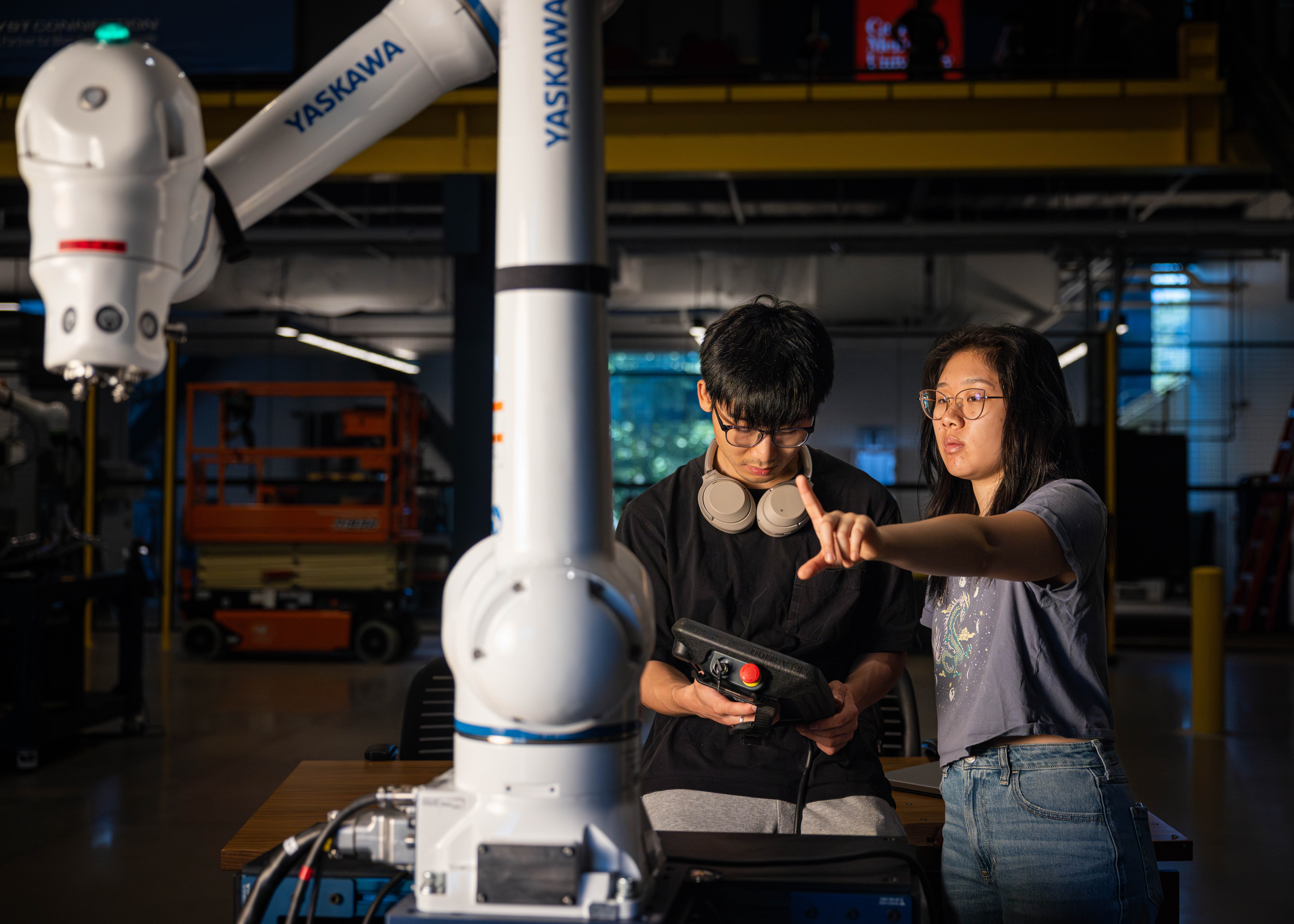 Students collaborating with industrial robotic arm