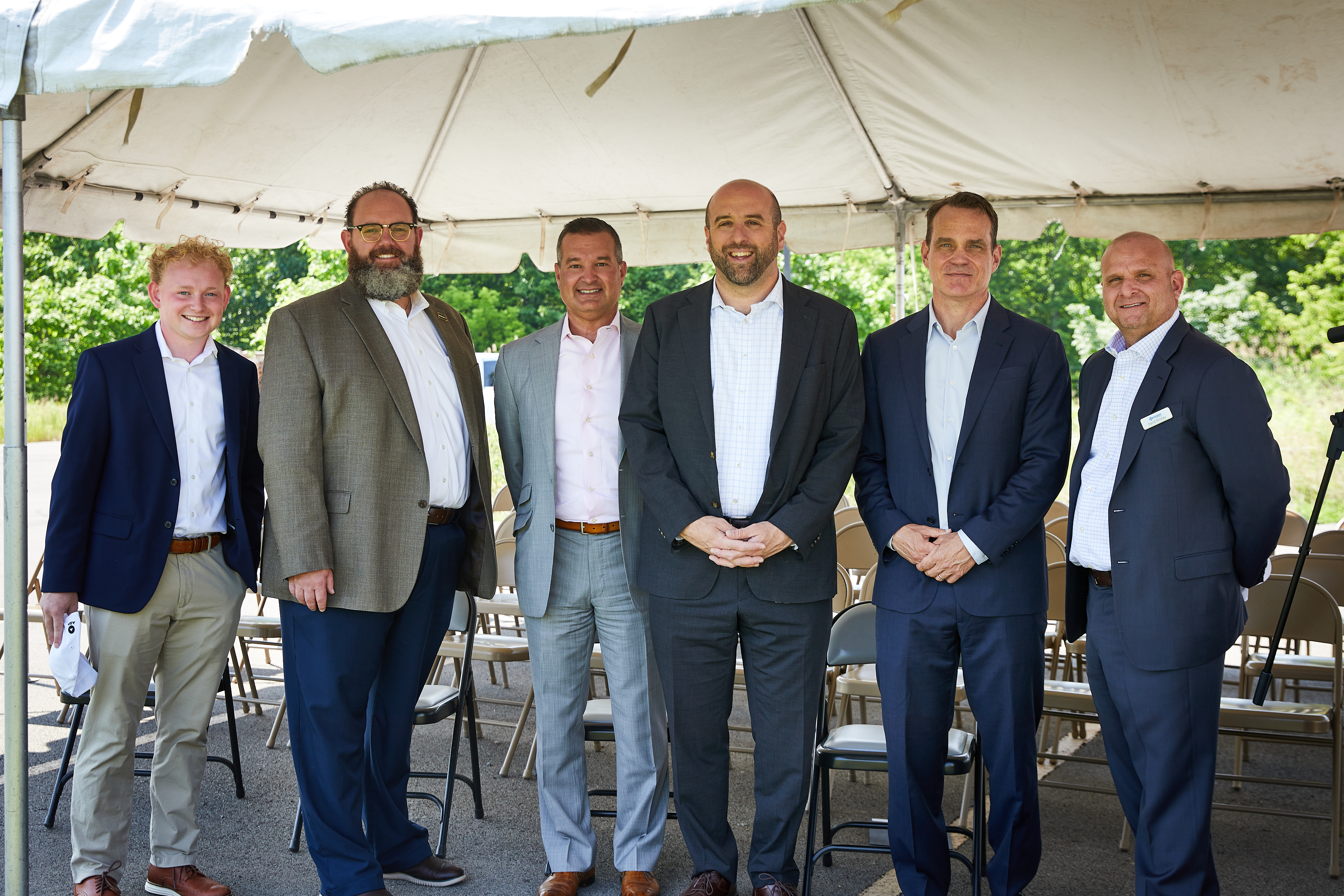 Secretary Rick Singer and five men posing for a photo under a tent at Berner ground breaking event.