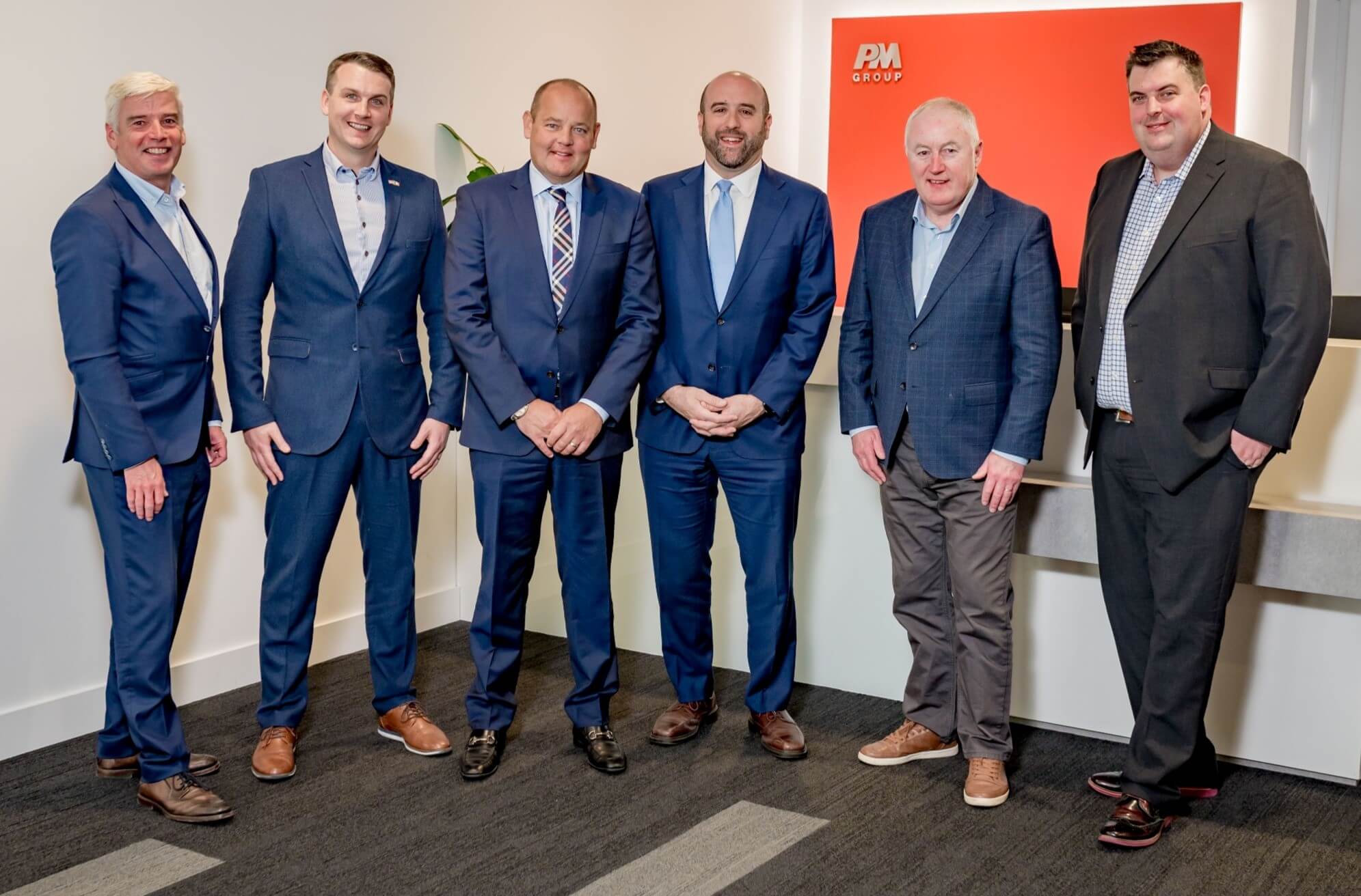 DCED staff and Secretary Rick Siger pose for a group photo with businesspeople in an office