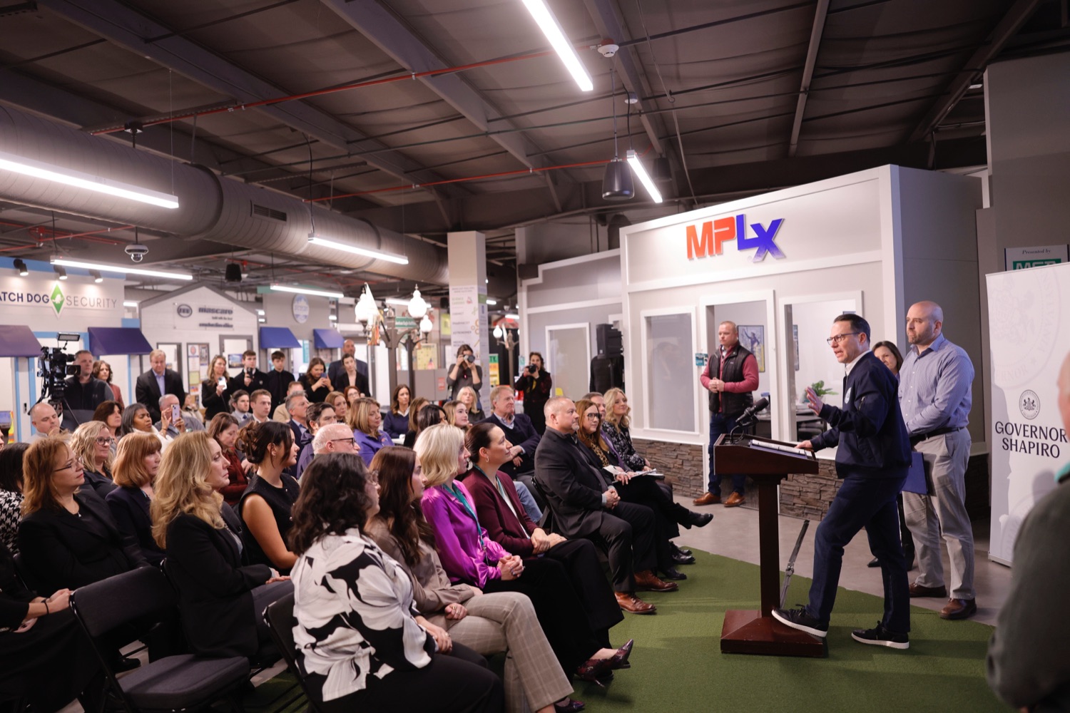 Governor Josh Shapiro speaks at a podium during a press conference at a youth manufacturing training center.