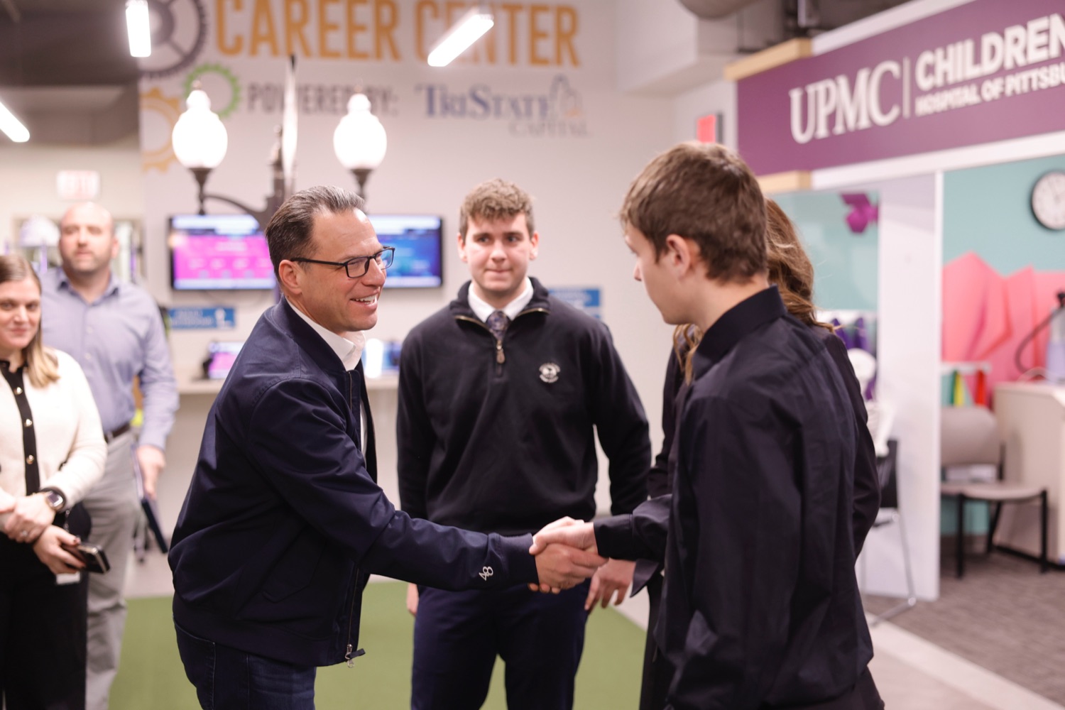 Governor Josh Shapiro shakes a boy's hand while visiting a youth manufacturing training center.