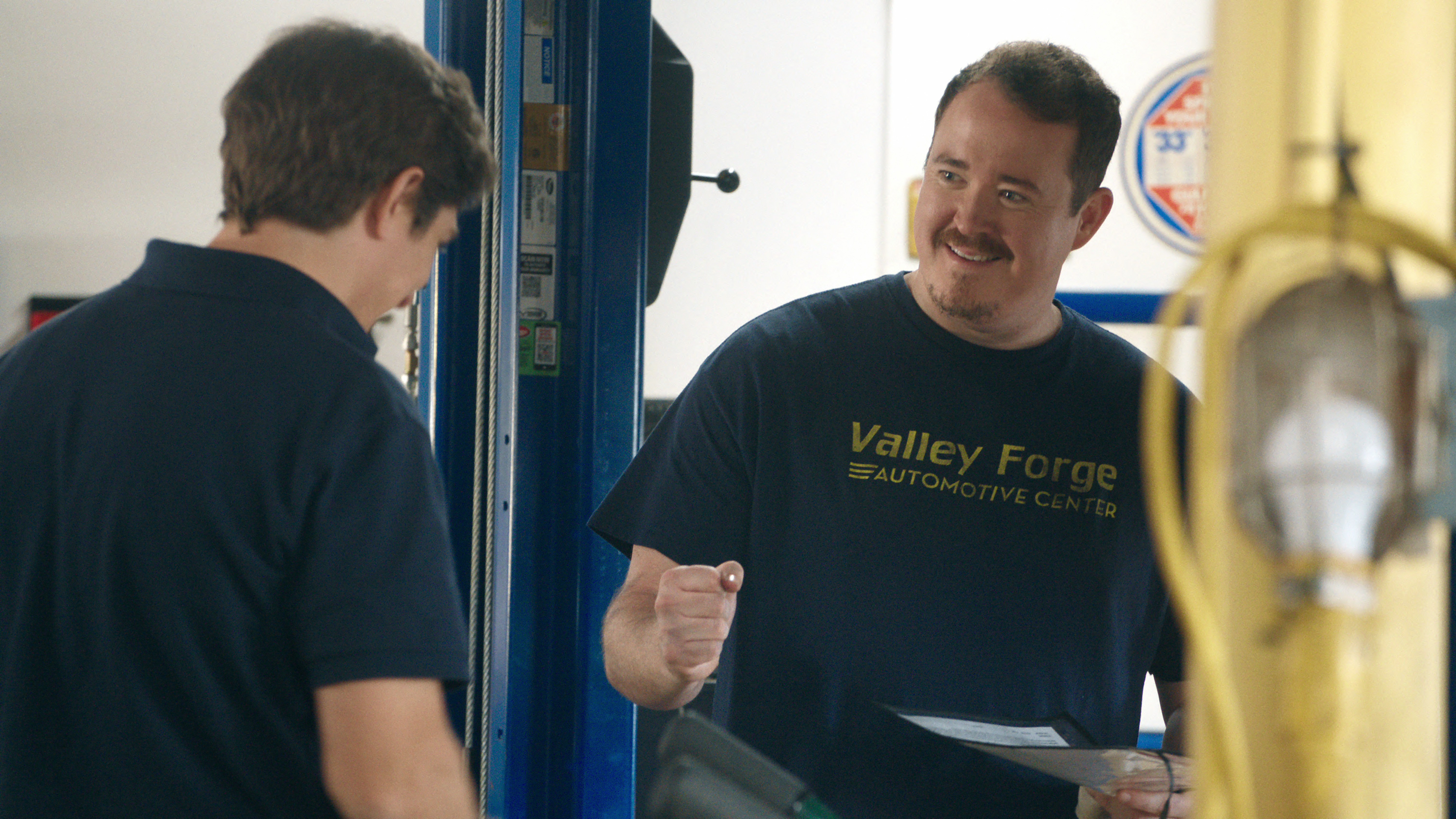 Shane Gillis reaches out for a fist bump while acting on the set of the television show Tires.  
