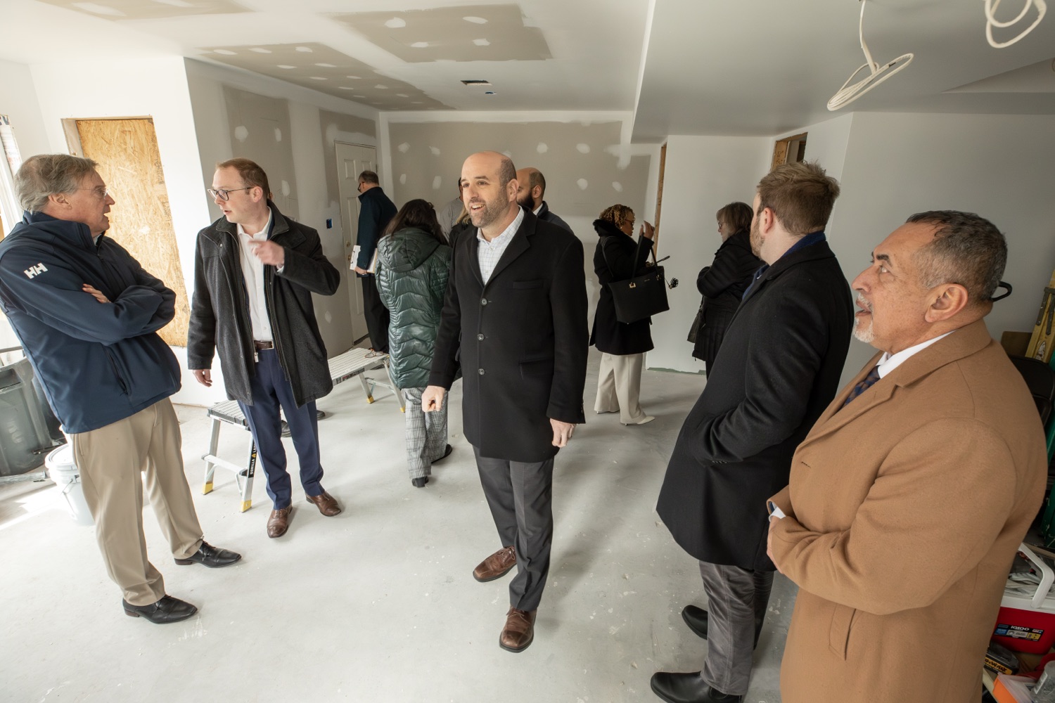 Secretary Rick Siger and a group of professionals tour an unfinished interior space