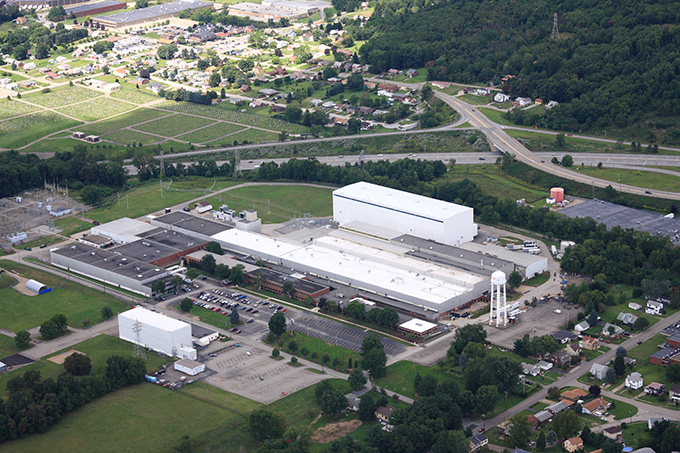 Aerial image of a large industrial manufacturing facility, surrounded by trees and farmland.