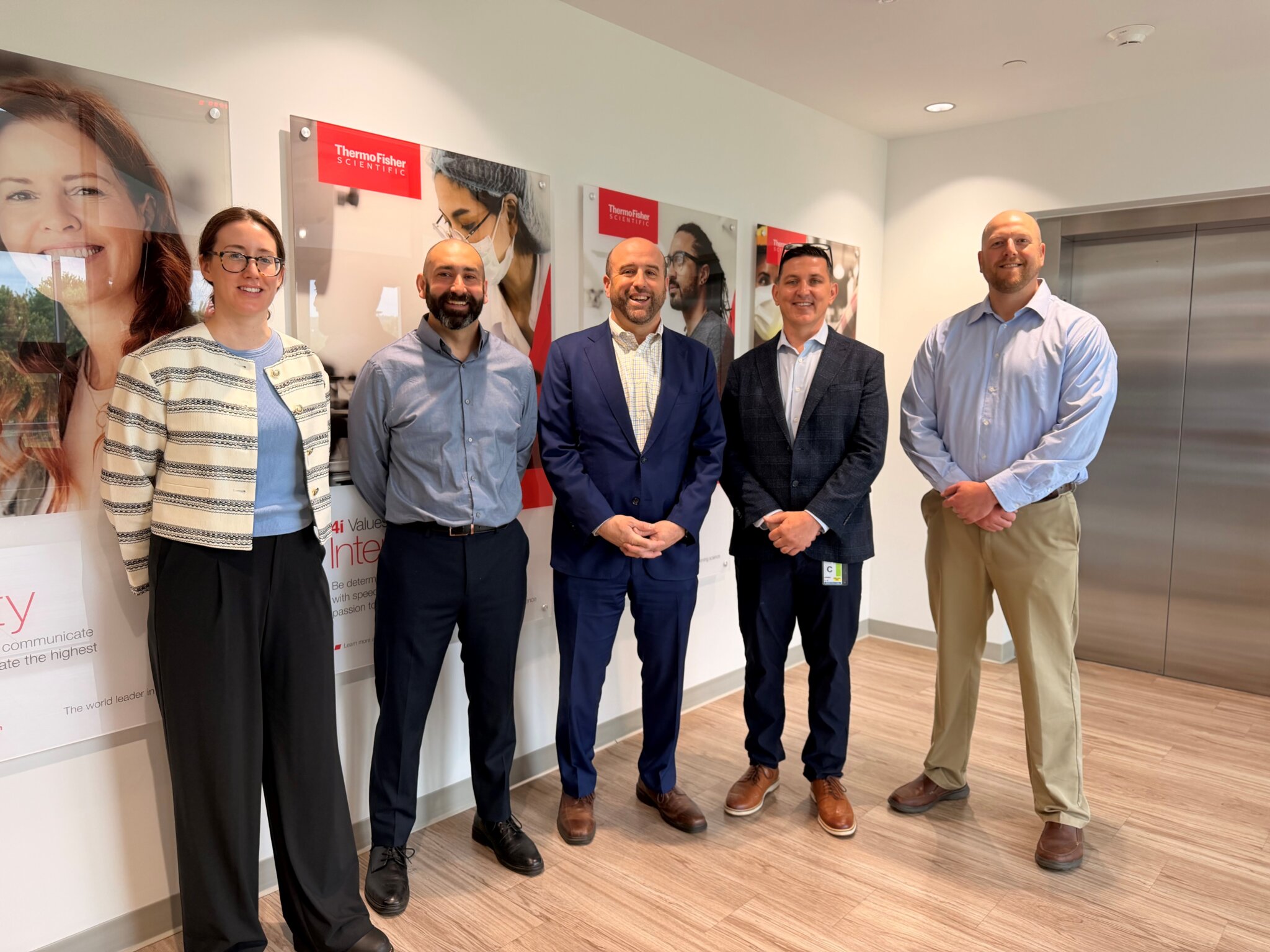 Rick Siger posing with crew of life science manufacturer Thermo Fisher Scientific Inc